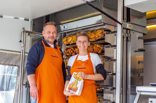 Illustratieve foto van een man en vrouw aan een kippenkraam op de markt